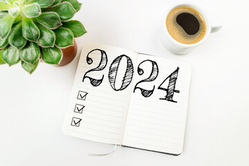 New year resolutions 2024 on white desk. 2024 resolutions list with notebook, coffee cup on table....