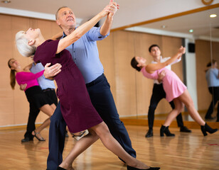 elderly man and woman having fun learning to dance waltz
