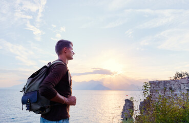 Fototapeta na wymiar Travel concept. Young man with rucksack enjoying the sea view
