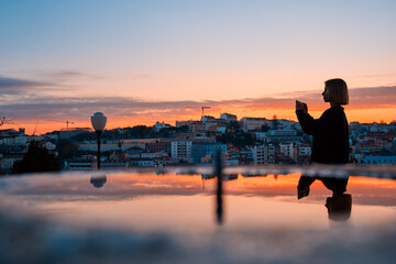 Traveling by Portugal. Young traveling woman enjoying old town Lisbon view at sunset time.