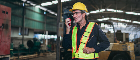 Portrait of engineer is working with tablet in the factory. Mechanical technicians are maintaining the engine.