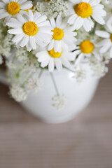 Bouquet with chamomiles and other wildflowers in silver can, copy space.