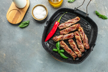 Grilled stuffed beef rolls in frying pan. banner, menu, recipe place for text, top view