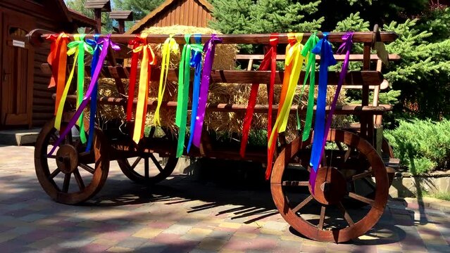 Symbol of equality, freedom, love. Colorful ribbons in the colors of the gay or lgbt rainbow flag flutter on a hay cart. LGBTQIA gay pride rainbow flag
