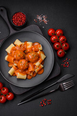 Delicious fresh meatballs and pasta in tomato sauce with salt, spices and herbs