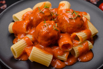 Delicious fresh meatballs and pasta in tomato sauce with salt, spices and herbs