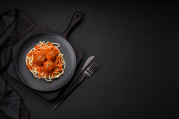 Delicious fresh meatballs and pasta in tomato sauce with salt, spices and herbs