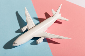 Model plane airplane on pastel blue and pink color background. Flat lay design. Flight and aircraft concept