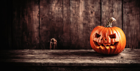 Obraz premium immagine con primo piano di zucca intagliata per la festa di Halloween, superficie sfondo in legno rustico e vecchio