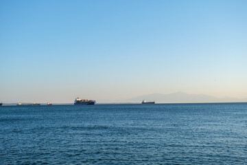 two container ships in the bay of thessaloniki by sunset