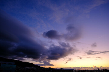 夜明け前。東の空が明るくなり、西宮の甲山の上空の雲がオレンジ色に染まる。神戸市内より撮影