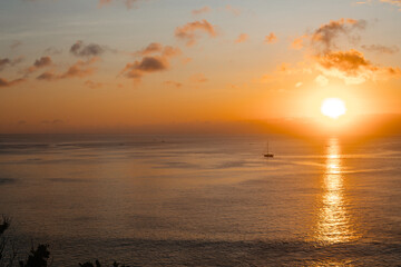 Beautiful orange sunset with the ocean and boat in the background. Scenic ocean views