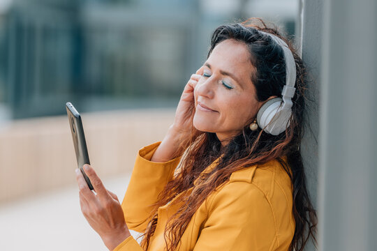 middle-aged woman with mobile phone and headphones
