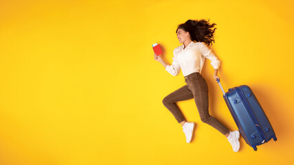 Happy Traveler Young Lady Running With Suticase On Yellow Background
