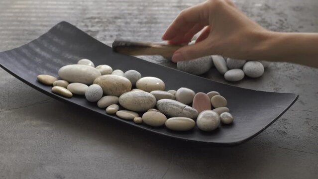 Burning Palo Santo stick with smoke on pebble stones 