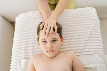 Closeup top view of cute five year old boy laying on bed at manual therapist in osteopath cabinet...