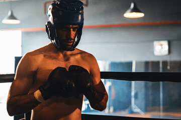 Boxing fighter with head guard posing, caucasian boxer punch his fist in front of camera in...