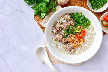 Minced pork boiled rice in a white bowl on background marble pattern. top view