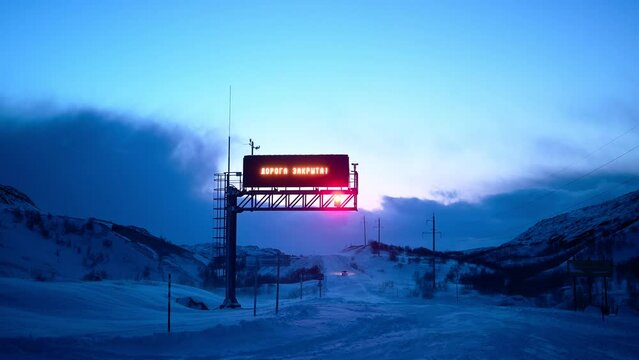 Closed road sign on the road from Teriberka to Murmansk. Snow blizzard at Teriberka, Murmansk, Russia
