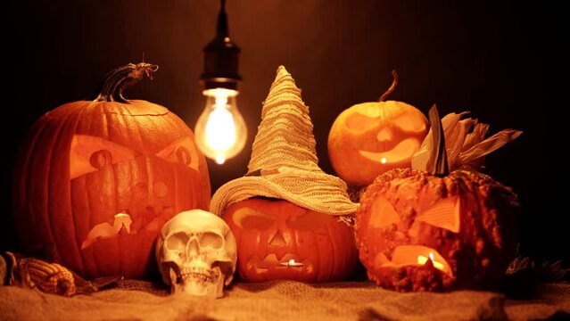 Halloween orange pumpkins with burning flickering candles lights. Horror set for seasonal holiday celebration. Carved Jack o lantern smile and scary eyes. Spirits night.