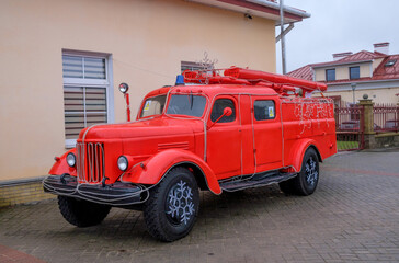 An old fire truck near the building of the fire department in Grodno, Belarus. The car is decorated for Christmas