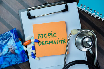 Concept of Atomic Dermatitis write on sticky notes with stethoscope isolated on Wooden Table.