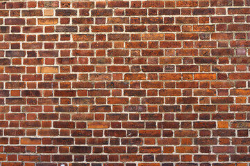Old brick wall made of dark red bricks. Texture of a brick wall