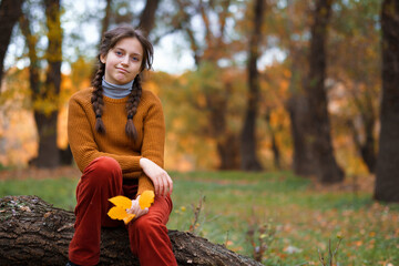 a young girl poses in autumn forest, fall season, beautiful nature