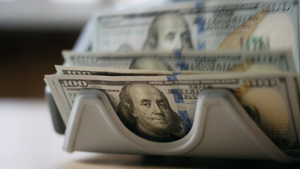 Electronic counter calculating dollar banknotes close up. Money cash calculation