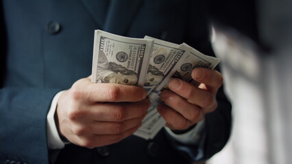 Businessman hands counting dollars close up. Unknown man calculating paper bills