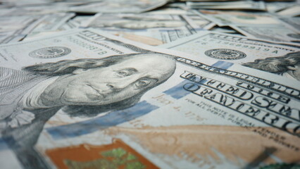Closeup hundred dollar banknote lying on large heap american currency rotating. 