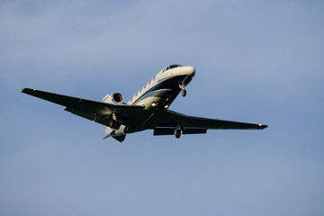  A small business jet approaching the airport with landing lights on.