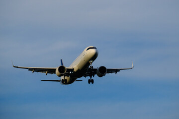 A commercial airplane approaching the airport during sunset.