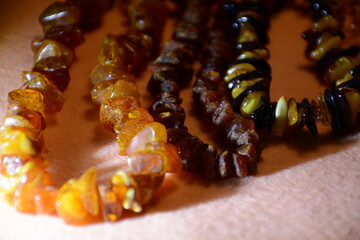 Raw amber beads on a pink background