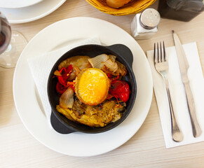 Appetizing escalibada of roasted eggplant, bell peppers, onions served with melted goat cheese. Traditional Spanish dish