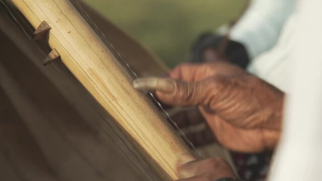 Hands plucking strings of Sasando, Traditional Music from Indonesia