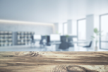 Close up of empty wooden desktop with product placement mock up place on blurry office interior backdrop. 3D Rendering.