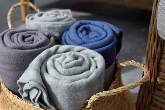 Fleece blankets twisted into rolls lie in a wicker basket.  Autumn time to warm up.