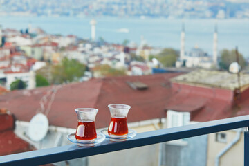 Two Turkish glasses filled with tea with view to the roofs of Uskudar district on Asian side of Istanbul, Turkey