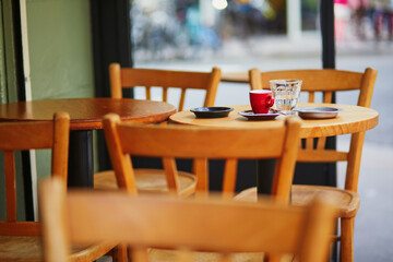 Cup of fresh espresso coffee on a table of traditional outdoor cafe in Paris, France