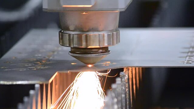Metal laser cutting. Cutting sheet of metal by laser metal cutting close-up. Industrial equipment machine for cutting metal in factory. Moving head with sparks. Metalwork manufacturing background
