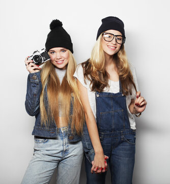 lifestyle, friendship, emotion and people concept: Happy hipster girls friends witn vintage camera