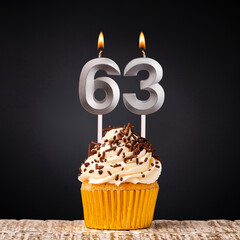 birthday cupcake with number 63 candle - Celebration on dark background