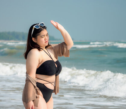 Portrait young woman asian chubby fat cute beautiful one person in bikini black sexy frontview tropical sea beach white sand clean and blue sky background calm nature ocean wave water travel fun happy