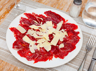 Sliced carpaccio. Raw beef meat on plate. Top view.