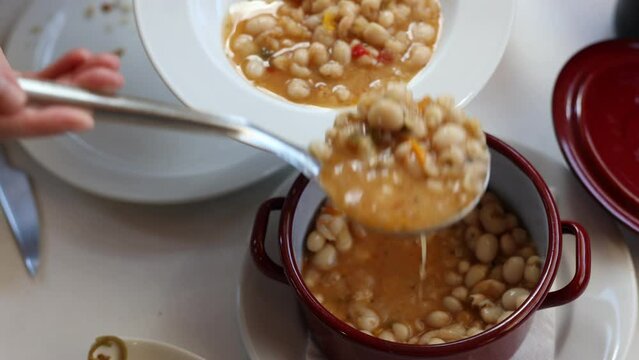 Pochas stewed with vegetables and ham bone in ladle. Aragonese cuisine. High quality 4k footage