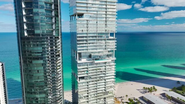 Aerial view of Sunny Isles Beach city with luxurious highrise hotels and condos on Atlantic ocean shore. American tourism infrastructure in southern Florida