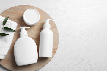 Different cosmetic products and towel on white wooden table, top view. Space for text