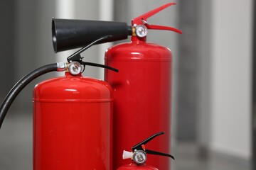 Three red fire extinguishers in hall, closeup