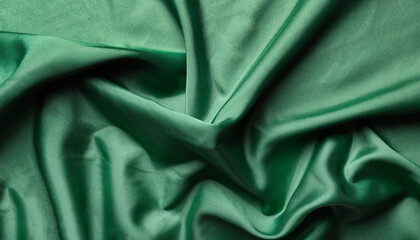 Crumpled dark green silk fabric as background, top view